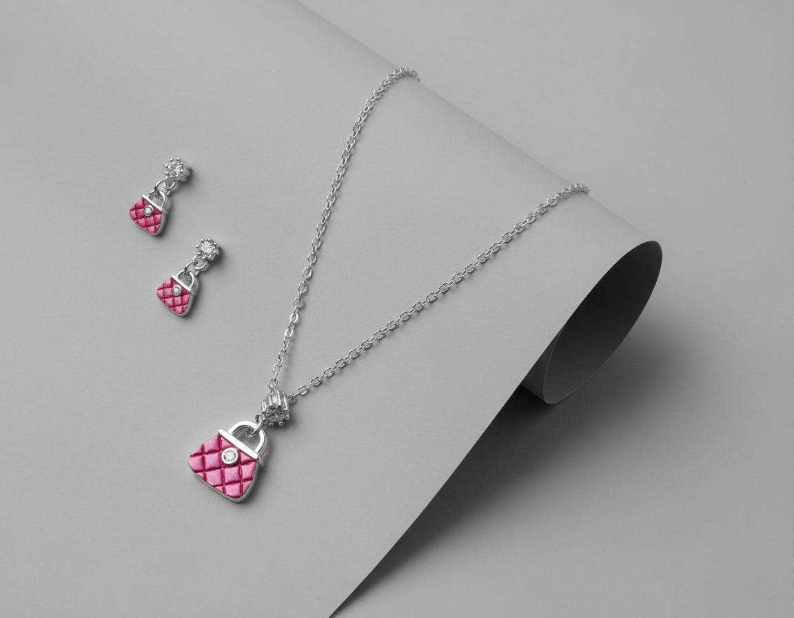 Jewelry set with pink heart pendant necklace and earrings on a maroon background