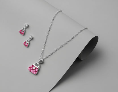 Jewelry set with pink heart pendant necklace and earrings on a maroon background