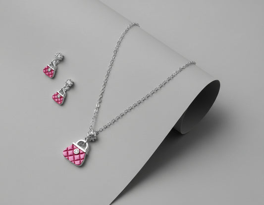 Jewelry set with pink heart pendant necklace and earrings on a maroon background
