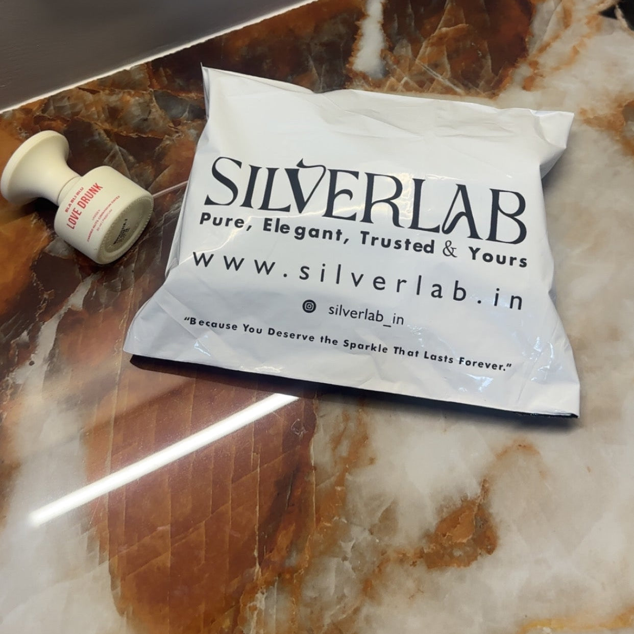 White pouch with 'Silverlab' branding on a marble countertop.